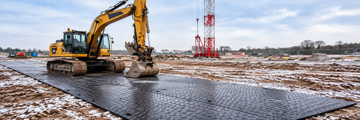 4x8 ground protection mats supporting an excavator on a winter construction site