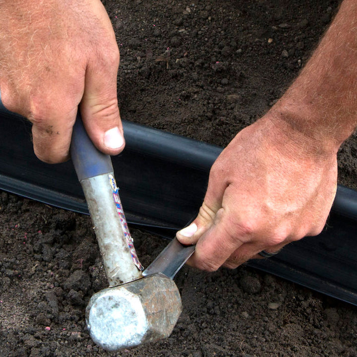 Steel landscape stakes securing metal edging along a garden walkway for a clean, stable border