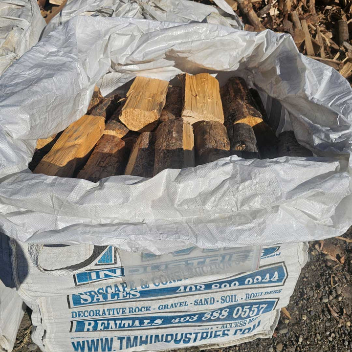 Pine firewood quarter bag from TMH Industries Calgary clean seasoned softwood ideal for fireplaces camping and outdoor fire pits available for pickup or delivery in Calgary